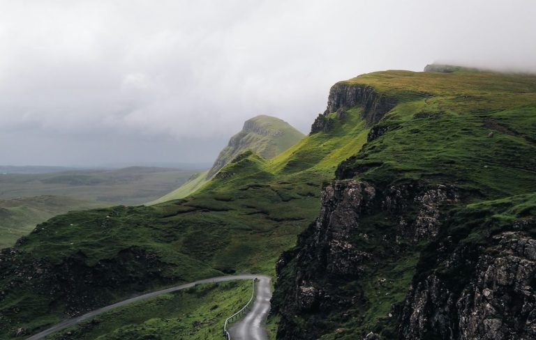 A winding road through the epic landscape of the Isle of Skye, Scotland, a destination reachable by booking a flight to Inverness via GlobalTravelGuideX.