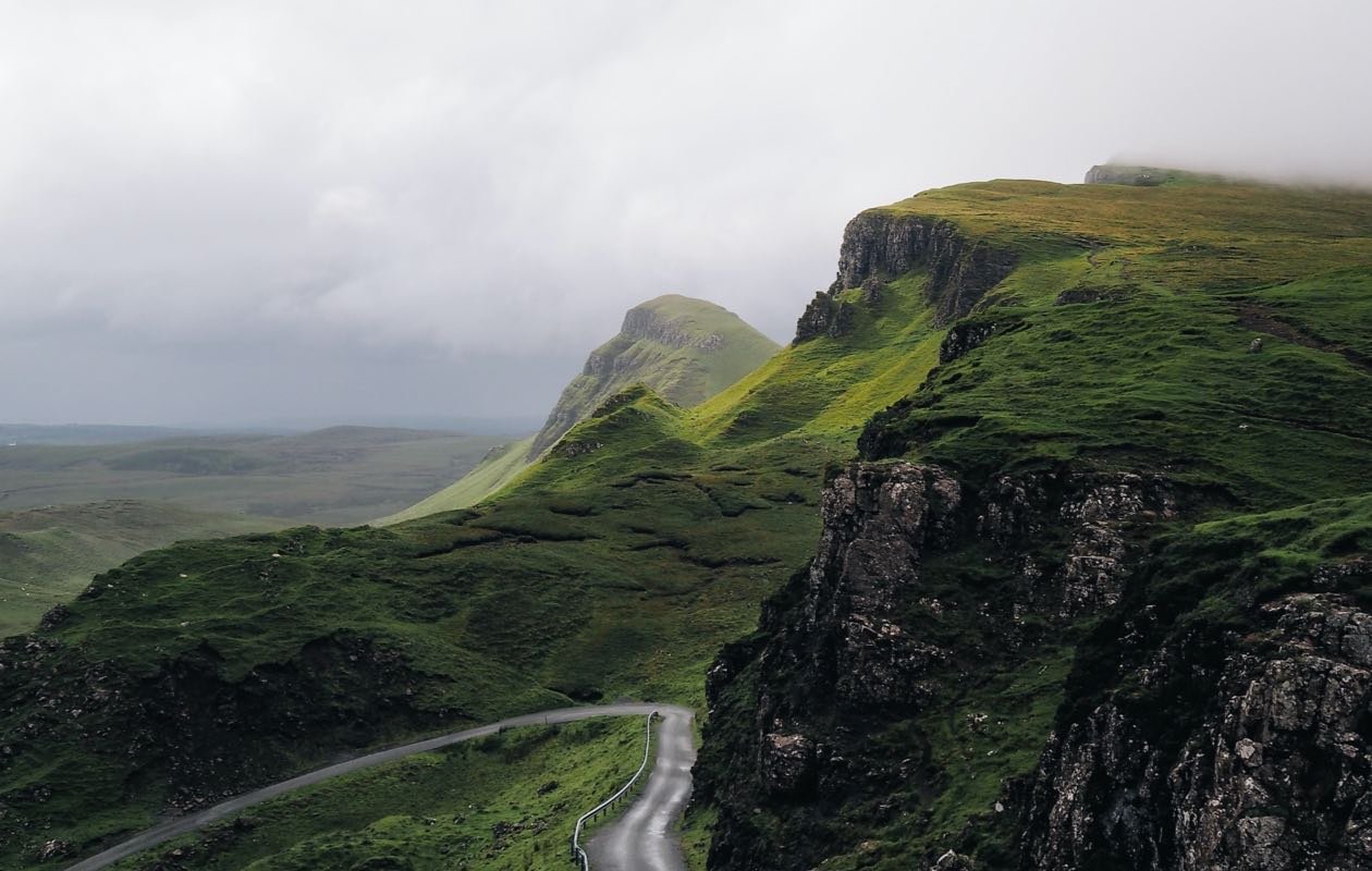 A winding road through the epic landscape of the Isle of Skye, Scotland, a destination reachable by booking a flight to Inverness via GlobalTravelGuideX.