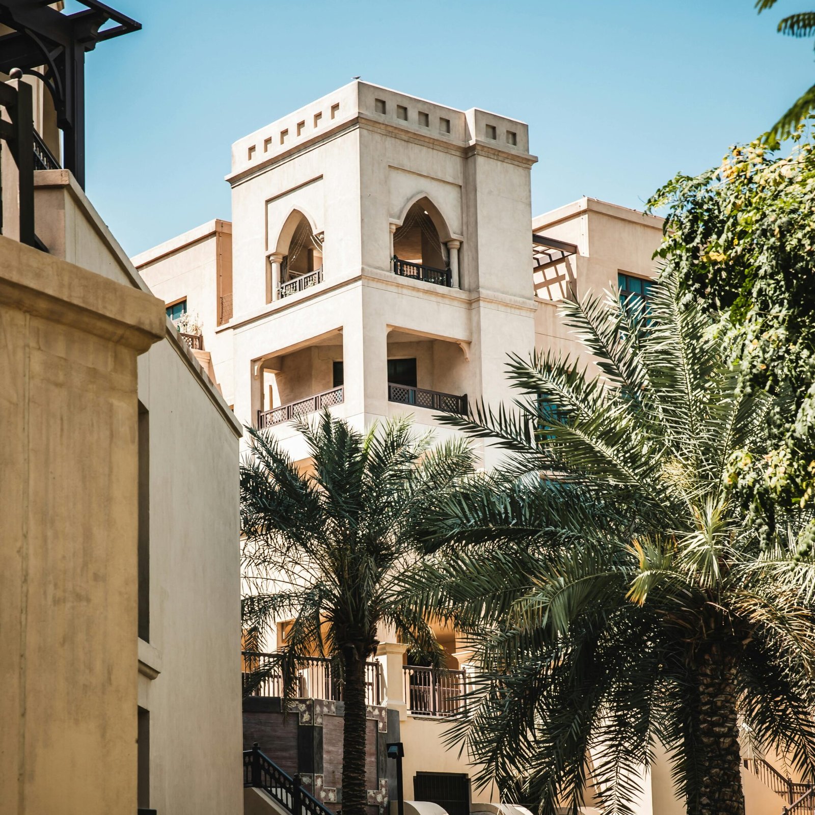 A luxury hotel with Arabian architecture and palm trees, an example of a hotel deal you can book on GlobalTravelGuideX.