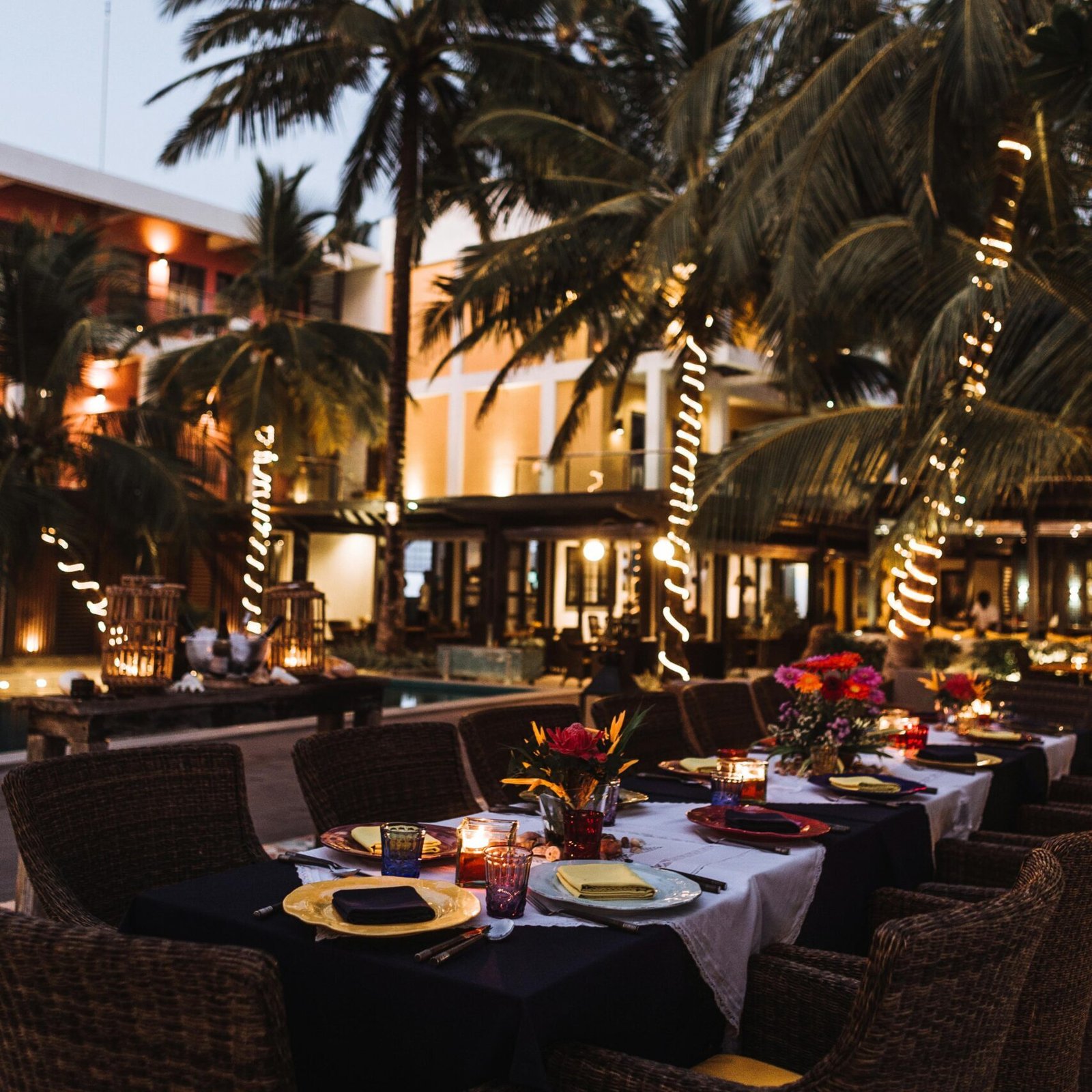 A romantic outdoor dinner setting at a tropical resort, the perfect experience after using GlobalTravelGuideX for your hotel booking.